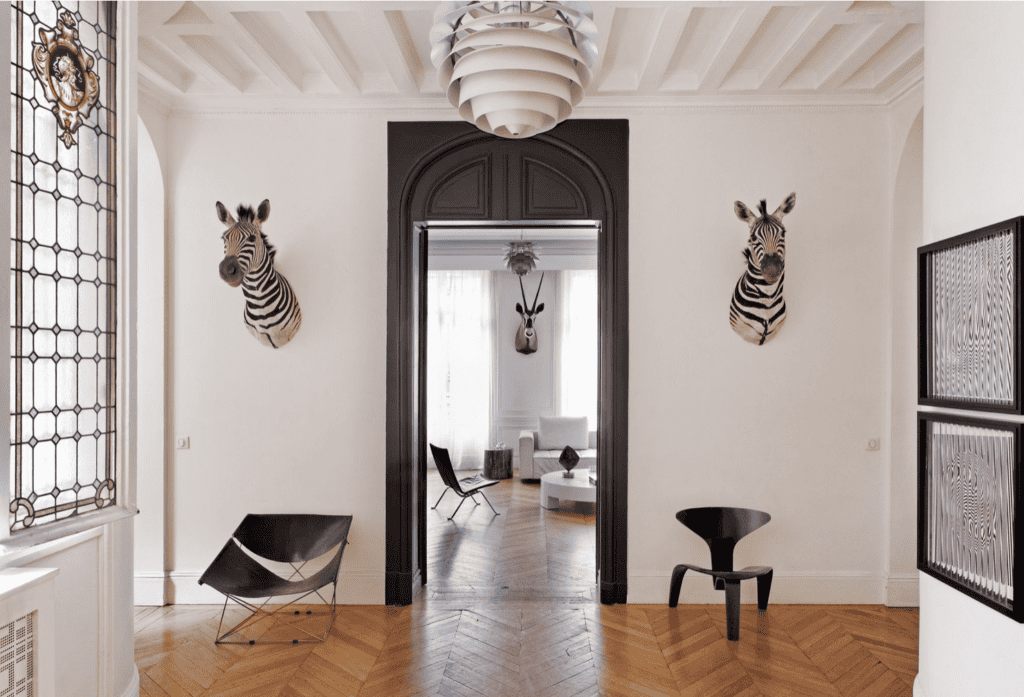 Zebra heads hanging near a black door frame.