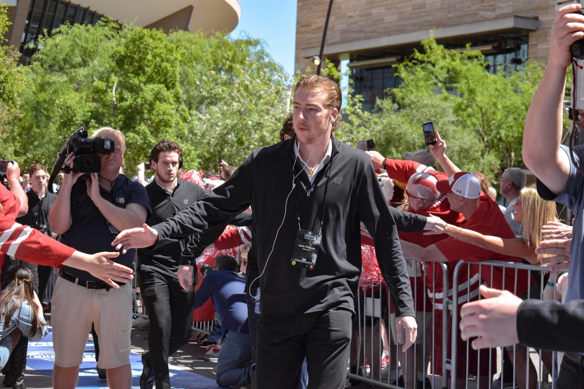 Jack Phelan shakes hands with Wisconsin hockey fans after stepping off the bus