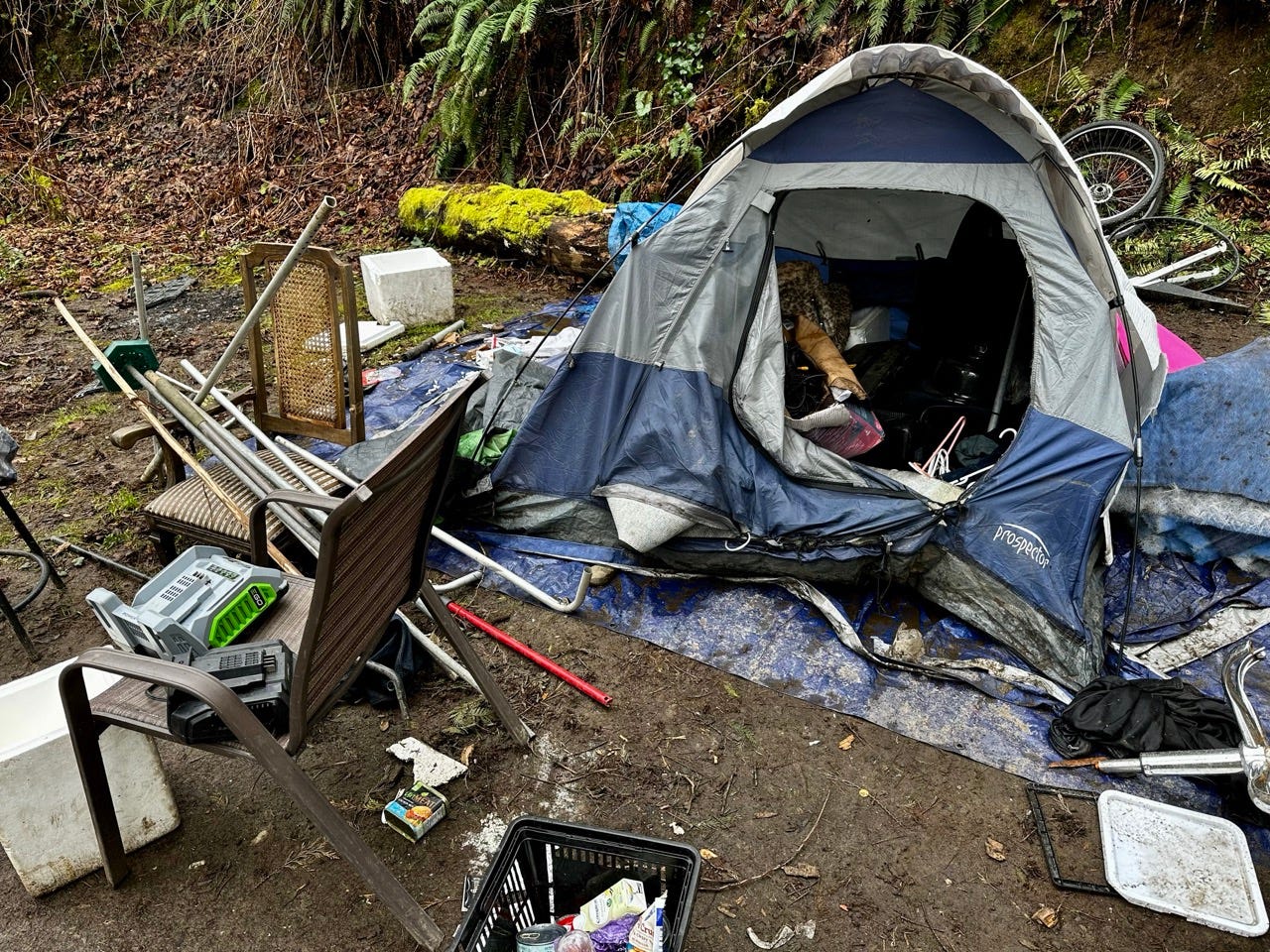 A tent with a bike and other objects on the ground

Description automatically generated