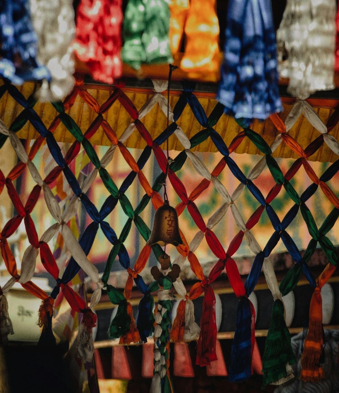 Colorful prayer flags and a small bell hanging Colorful prayer flags and a small bell hanging