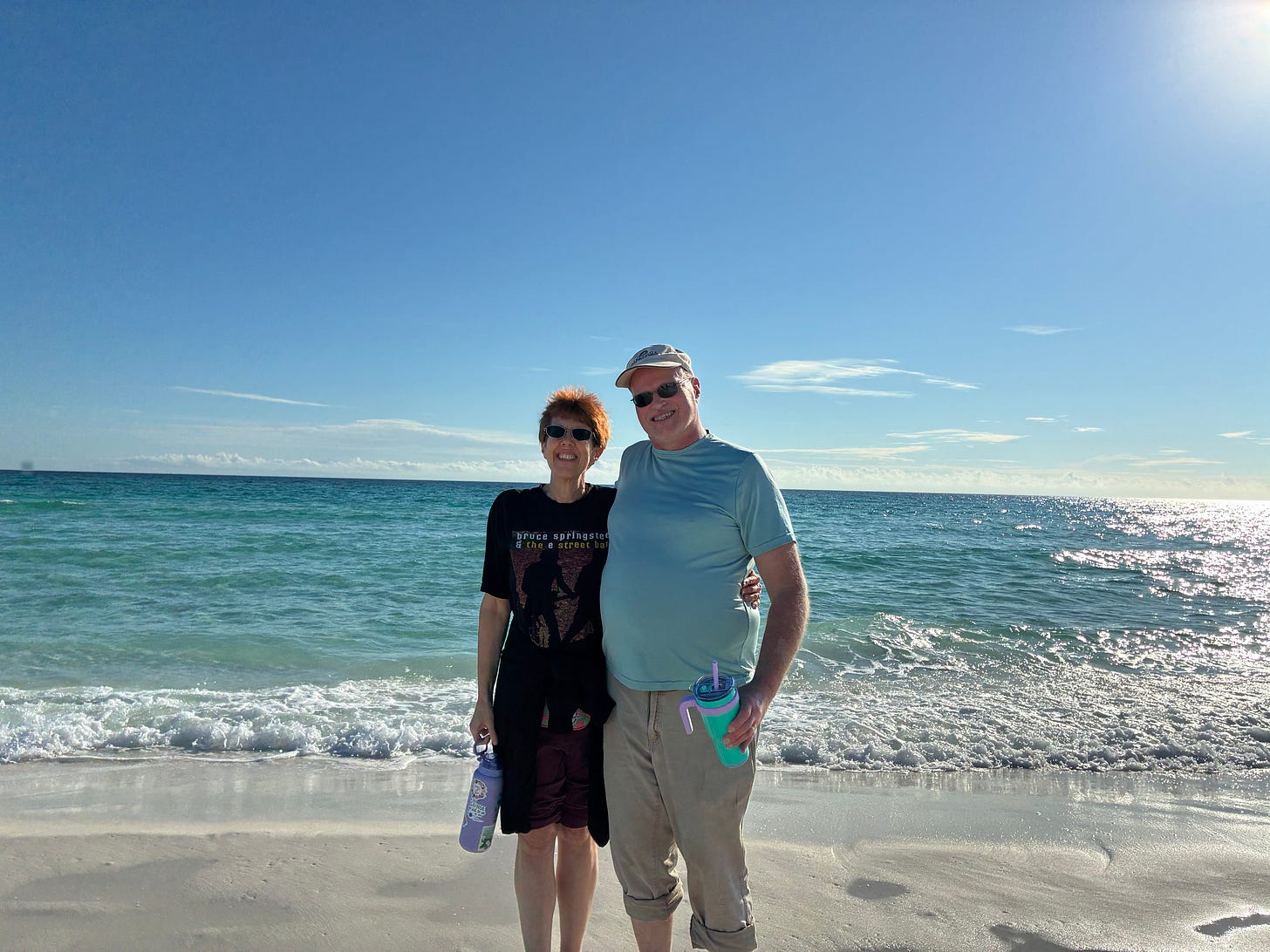 The author and her husband standing on the beach in Destin, FL