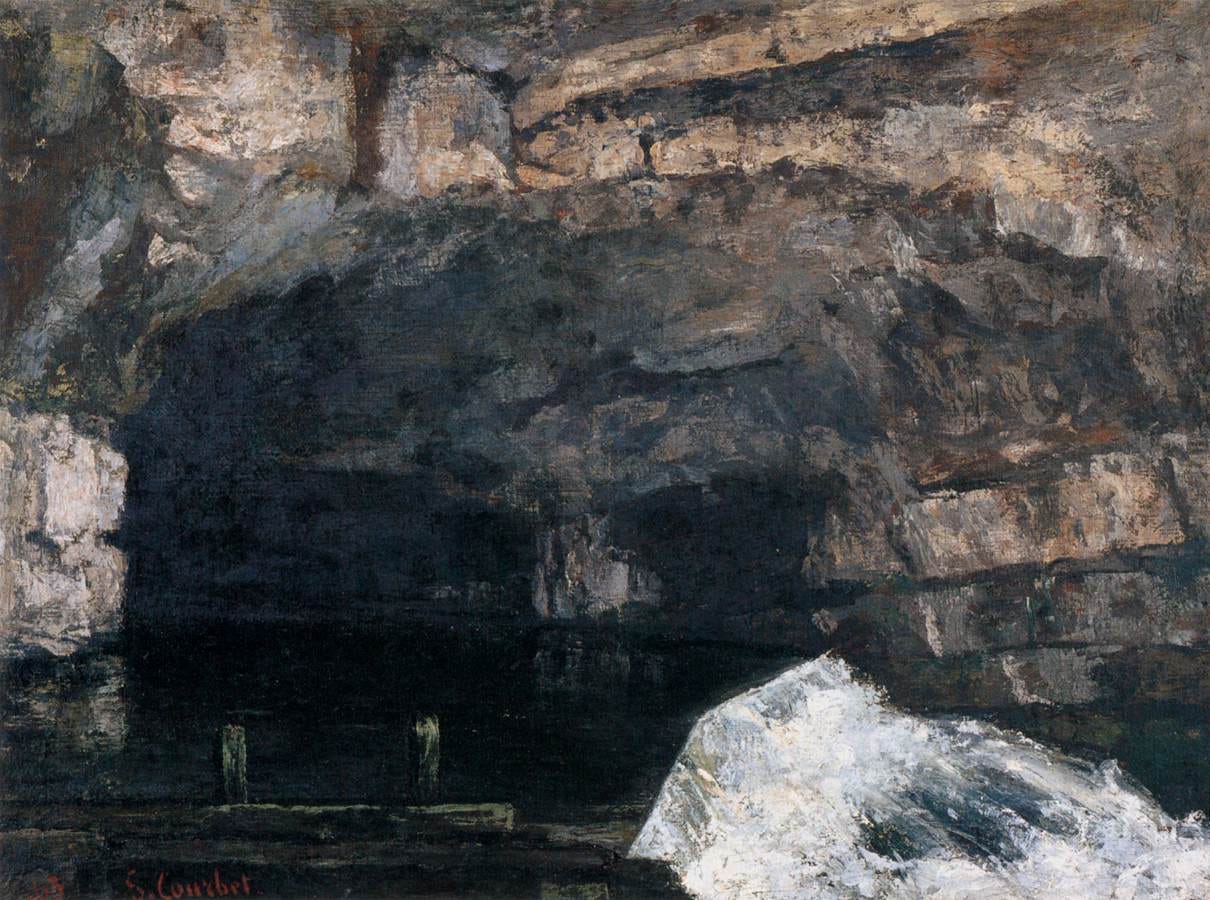 Water gushes from a dark cave mouth in a limestone cliff into a cold stream Water gushes from a dark cave mouth in a limestone cliff into a cold stream