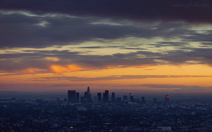 This may contain: an airplane flying over the city at sunset