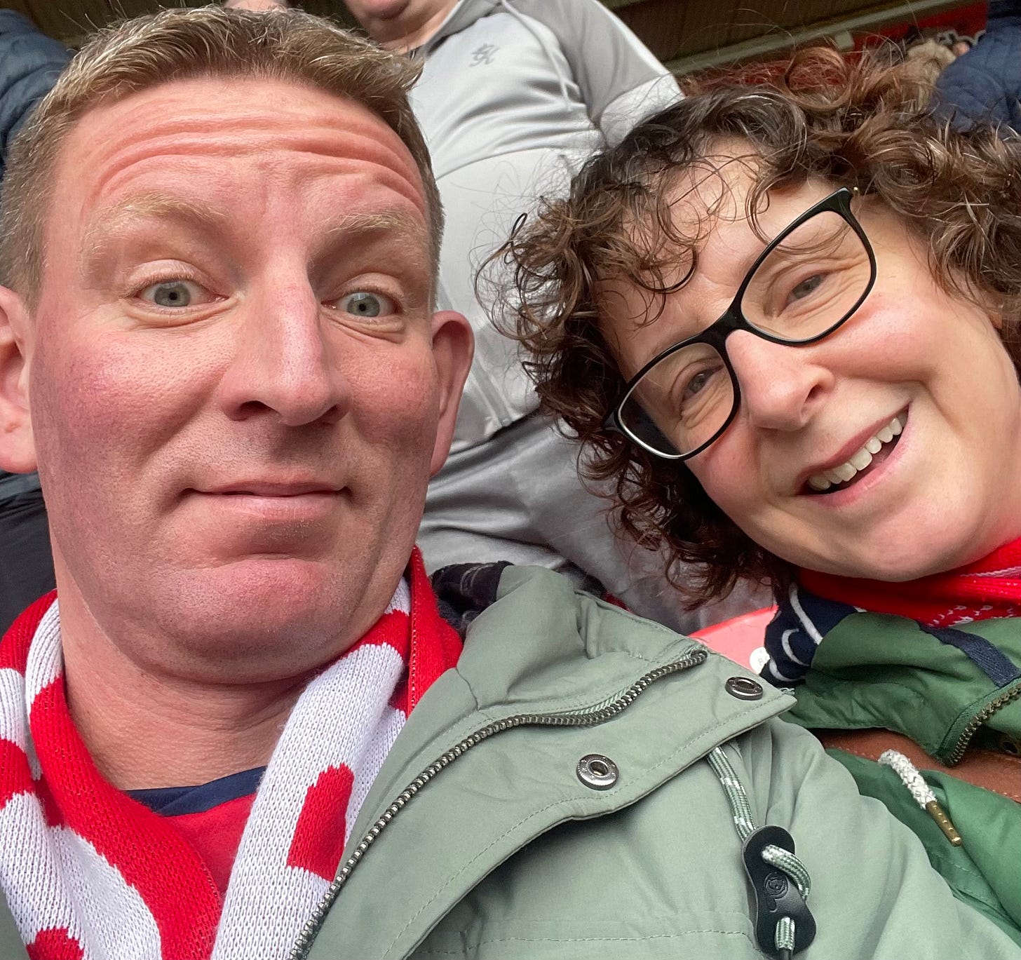 Liz and Ben apparently enjoying themselves. Both are wearing football scarves.