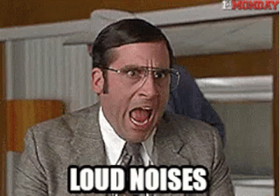 a man in a suit and tie is screaming with his mouth open and the words `` loud noises '' written next to him . a man in a suit and tie is screaming with his mouth open and the words `` loud noises '' written next to him .