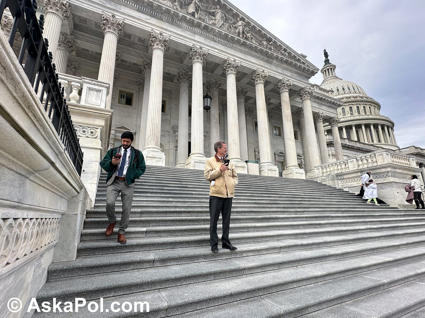 Two men in ties and casual coats are on their phones on the steps of the US Capitol. Photo: Matt Laslo Two men in ties and casual coats are on their phones on the steps of the US Capitol. Photo: Matt Laslo