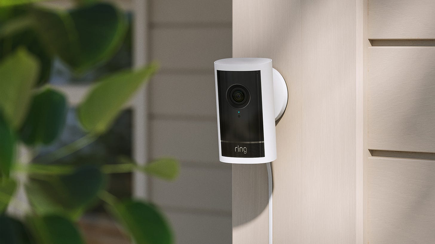 Ring video doorbell mounted on exterior wall near greenery