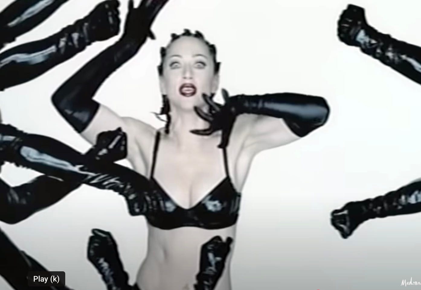 Madonna Human Nature video Madonna is in a pvc bikini sourrounded by dancers and looking incredulous