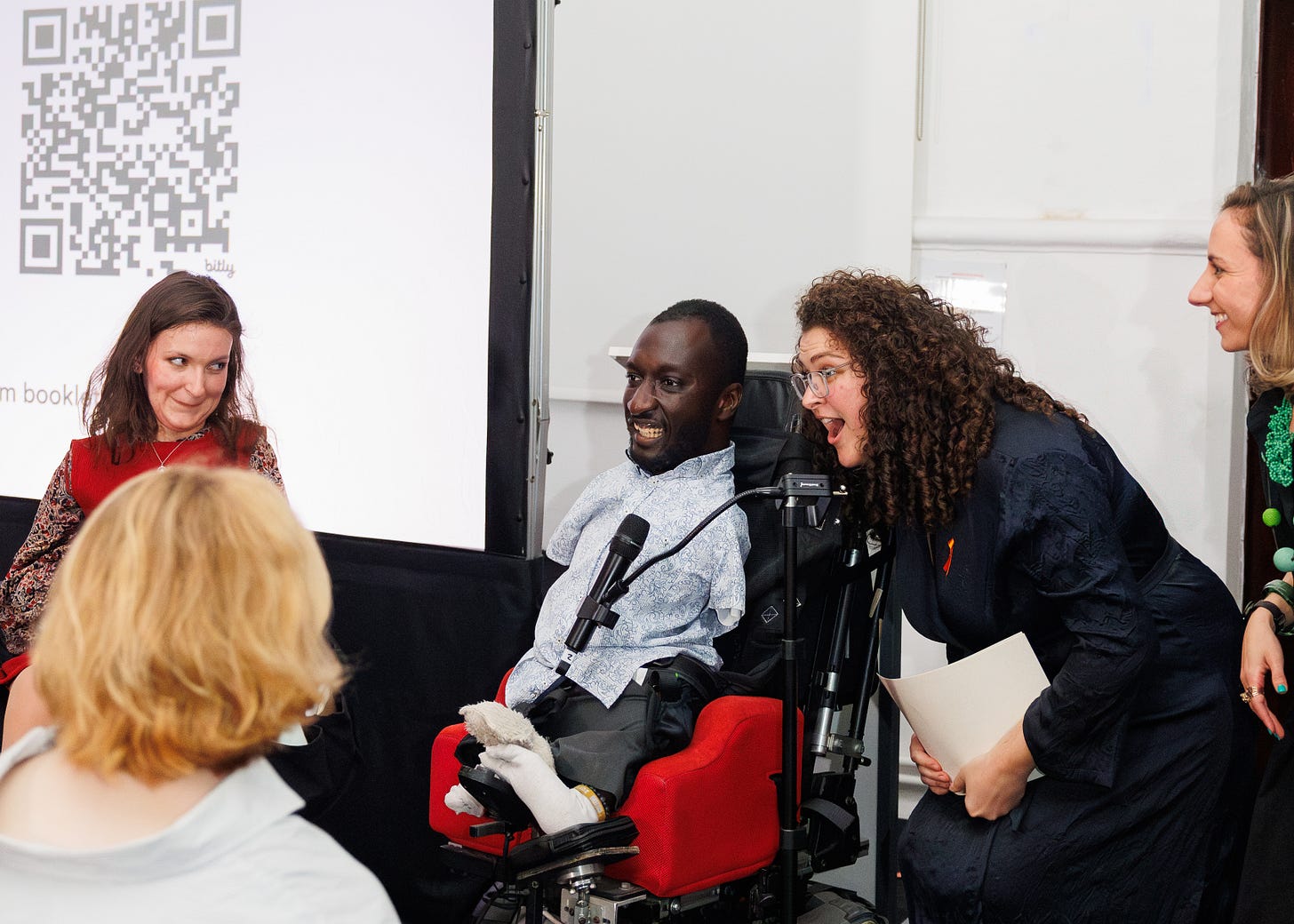 A candid event photo showing two of the disability mentors: Anna Landre and Isaac Harvey MBE who are presenting the Community Choice award.