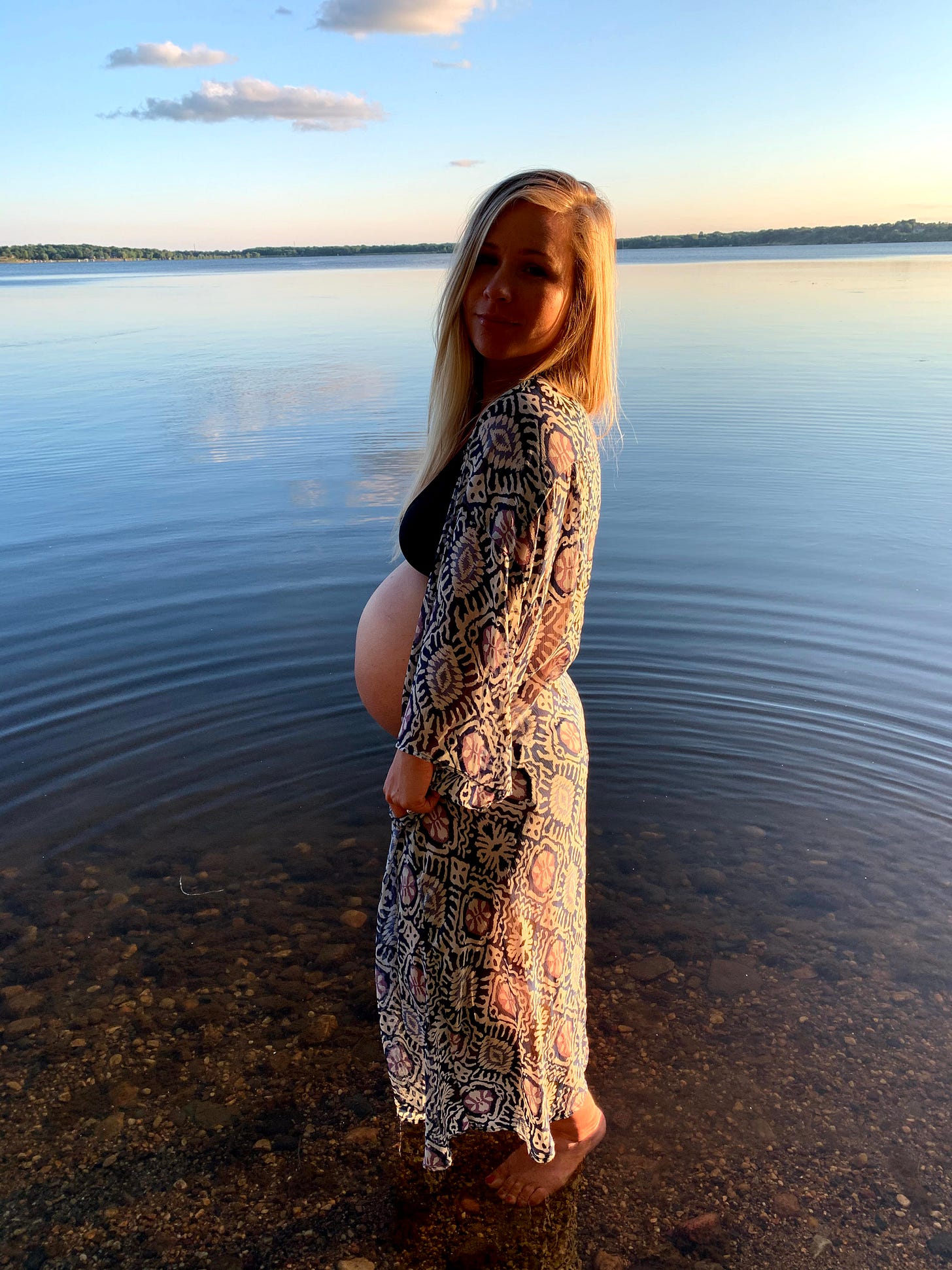 pregnant Seana standing by a lake at sunset before her sons early arrival pregnant Seana standing by a lake at sunset before her sons early arrival