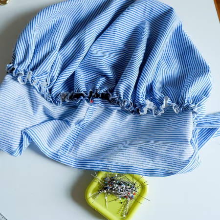 the gathered fabric edge of the bonnet is pinned to the fabric strip the gathered fabric edge of the bonnet is pinned to the fabric strip