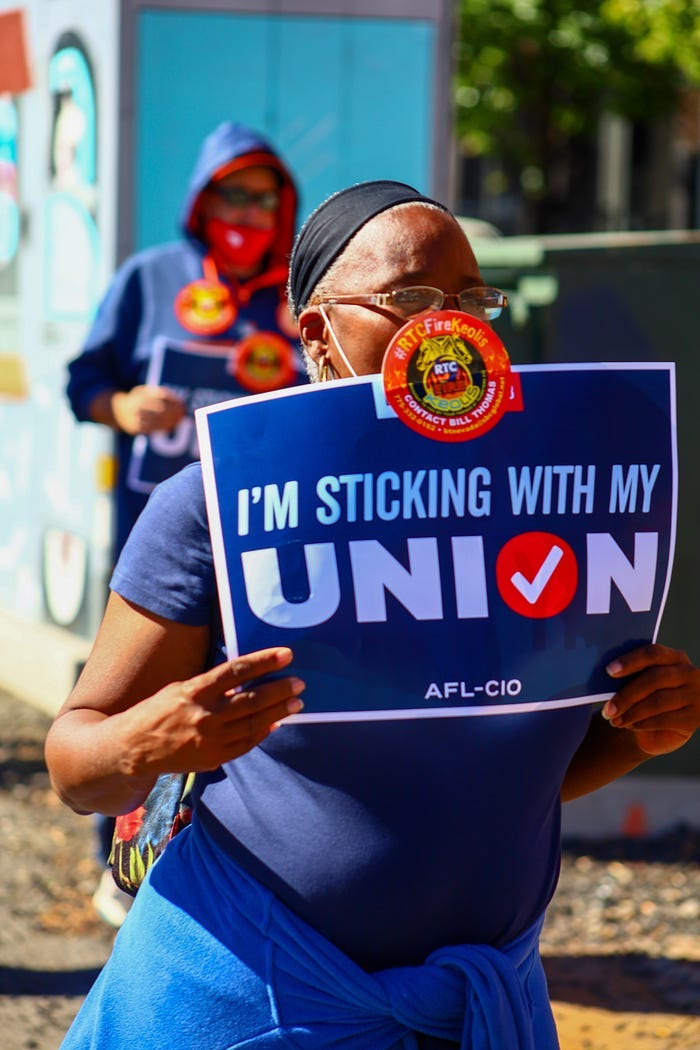 A striking worker holds up a sign, proclaiming: “I’m sticking with my Union!” A striking worker holds up a sign, proclaiming: “I’m sticking with my Union!”