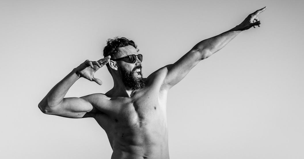 grayscale photo of topless man wearing sunglasses grayscale photo of topless man wearing sunglasses