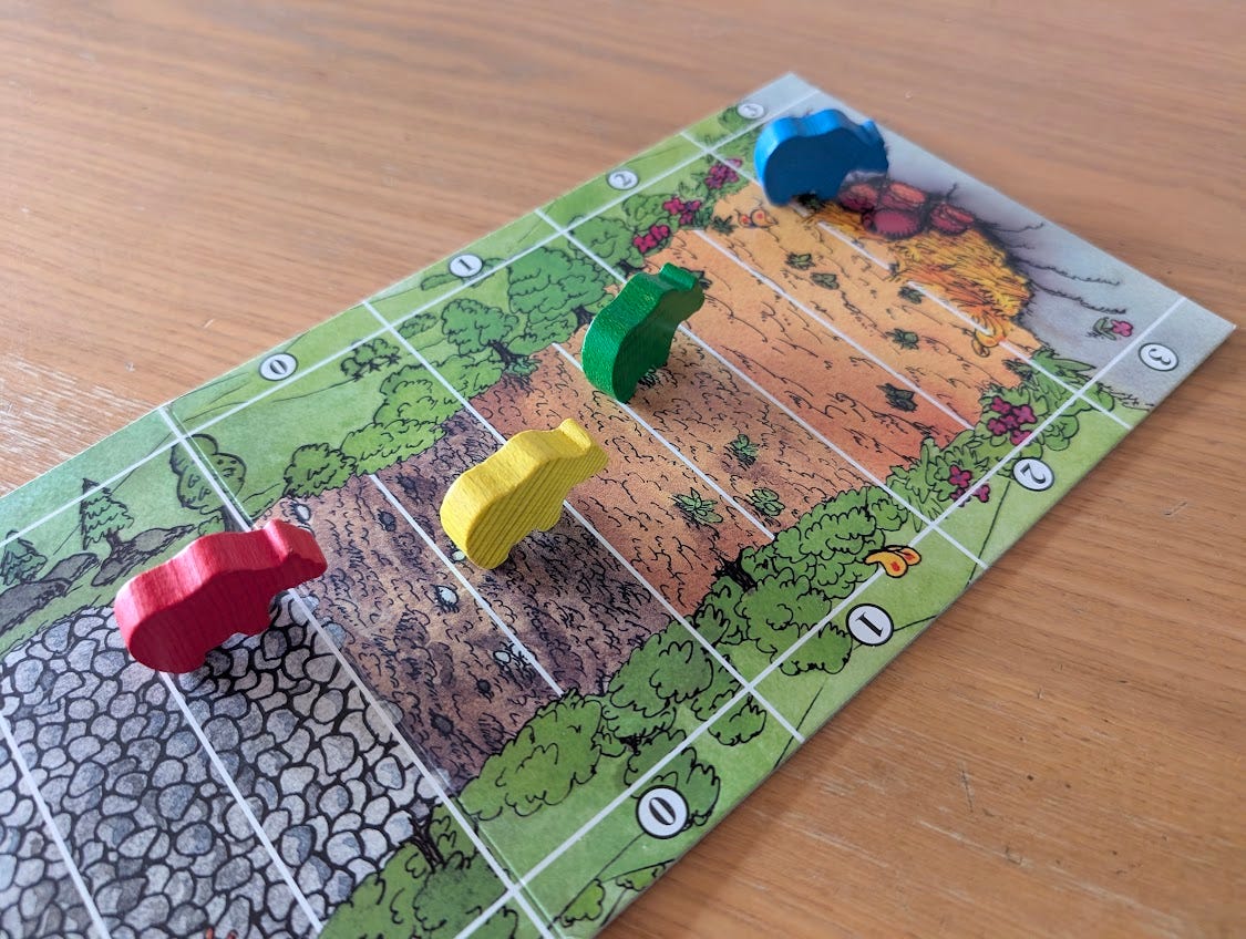 Vier Bären aus Holz in den Farben rot, gelb, grün und blau stehen auf einem Spielplan. Dieser zeigt einen Weg zu einer Höhle, in der Honigtöpfe stehen. Am Wegesrand sind Punktzahlen abgebildet. Vier Bären aus Holz in den Farben rot, gelb, grün und blau stehen auf einem Spielplan. Dieser zeigt einen Weg zu einer Höhle, in der Honigtöpfe stehen. Am Wegesrand sind Punktzahlen abgebildet.