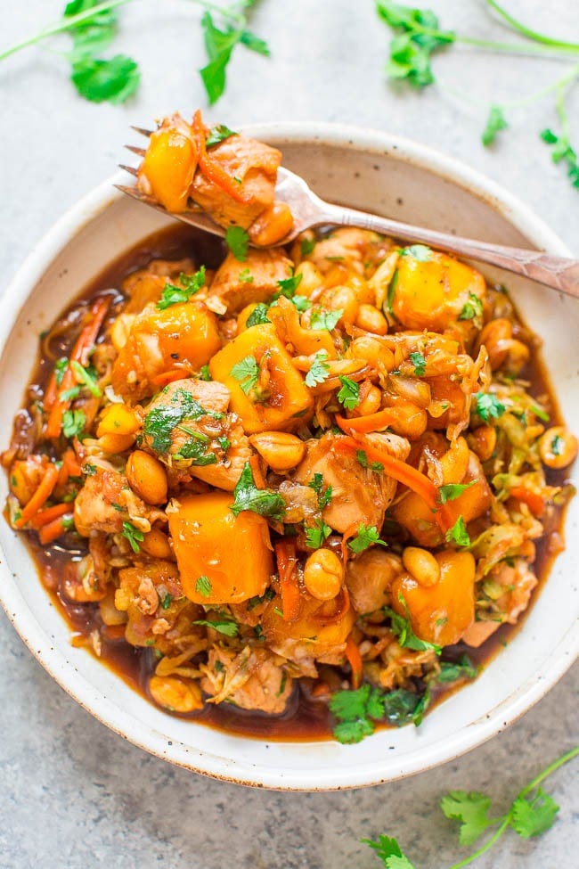Sesame Mango Chicken in large white bowl with a fork. 