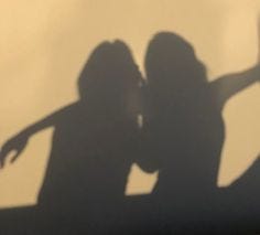 This may contain: the shadow of two people holding their arms out in front of a white wall with shadows on it