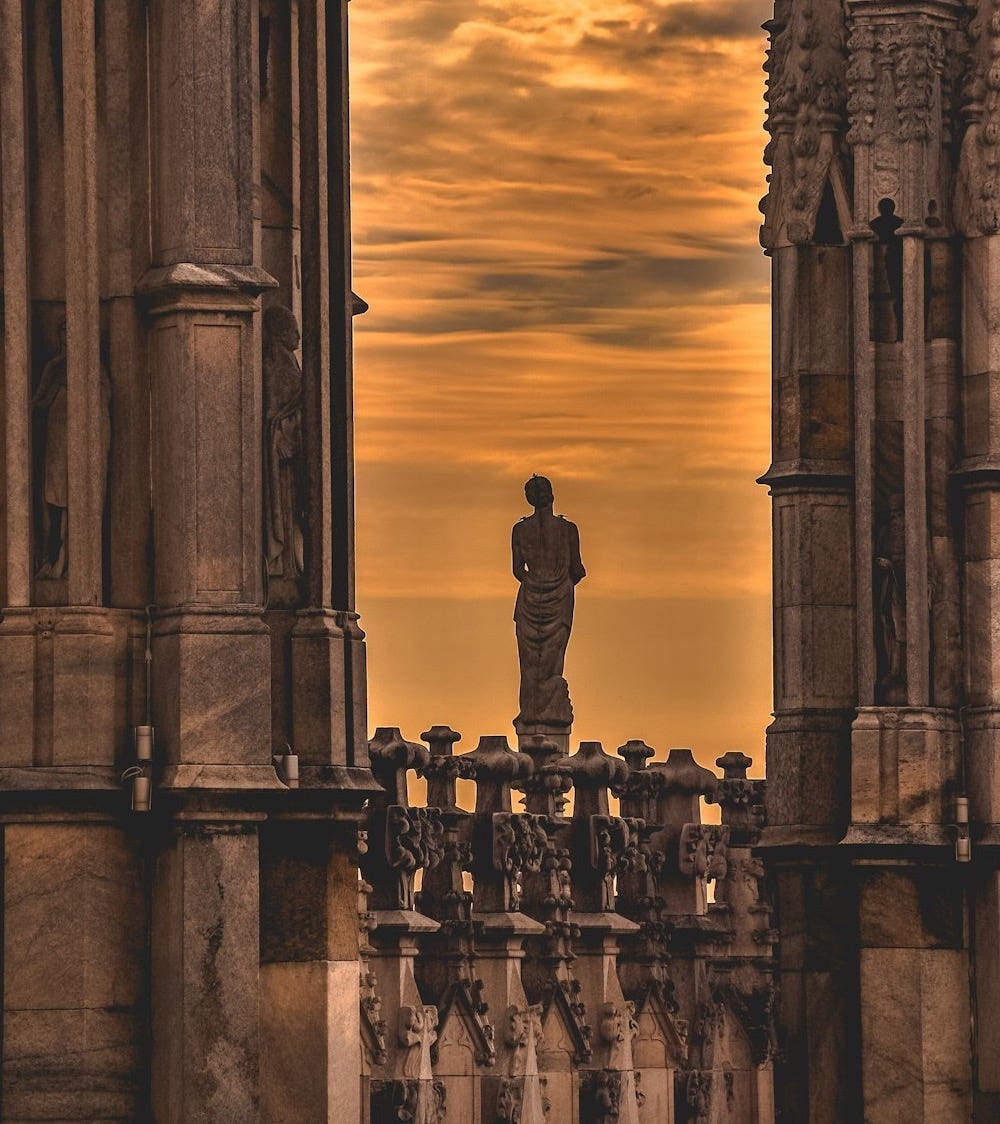 low-light photo of woman statue in the middle of high-rise building