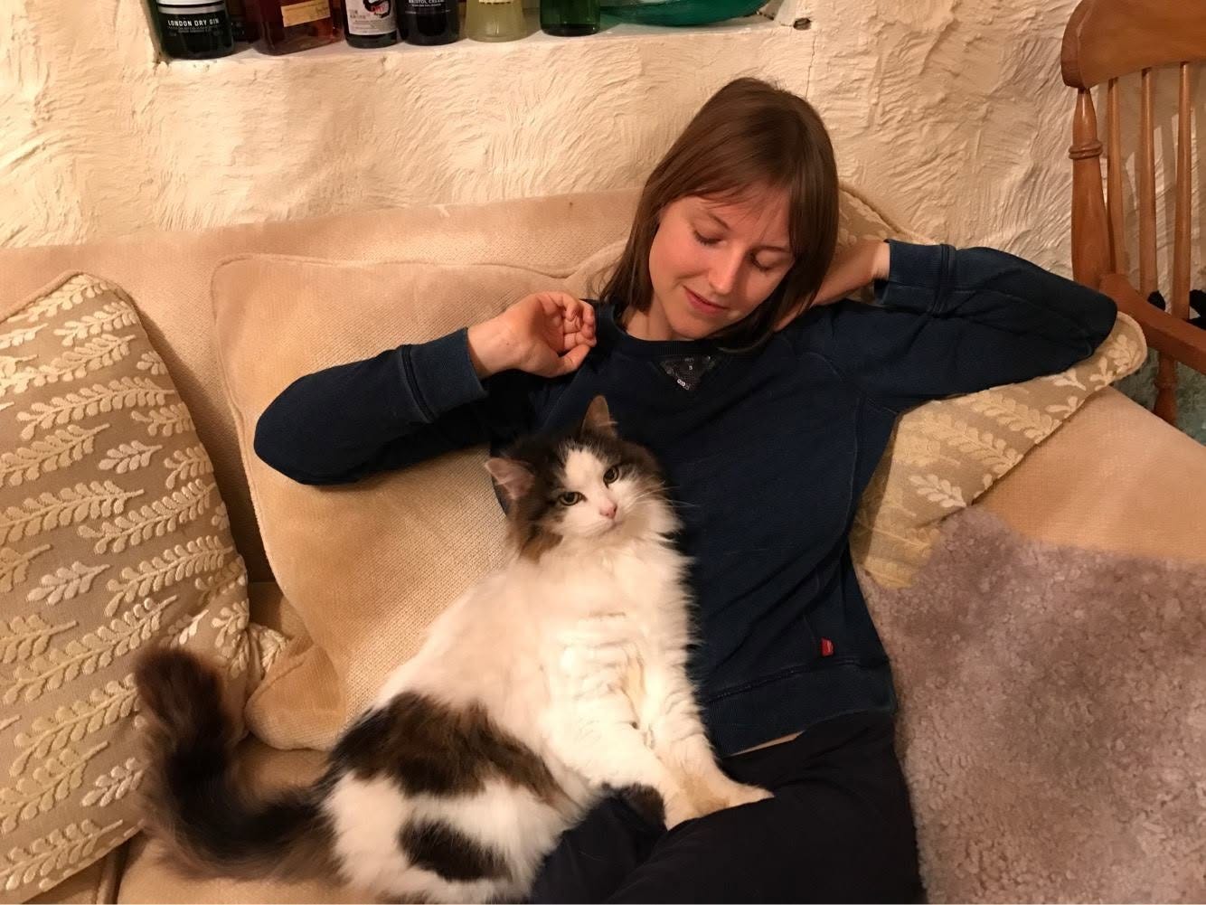 Elizabeth Sulis Kim relaxing on a sofa with a large black-and-white cat during her Tarot DMs interview. Elizabeth Sulis Kim relaxing on a sofa with a large black-and-white cat during her Tarot DMs interview.