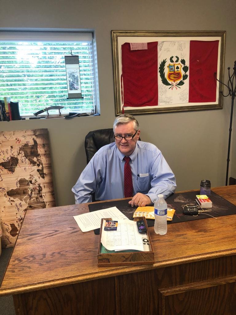 Austin Gardner in Office with Peruvian flag