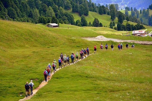A line of pilgrims walking along the Camino de Santiago through the Spanish countryside. A line of pilgrims walking along the Camino de Santiago through the Spanish countryside.