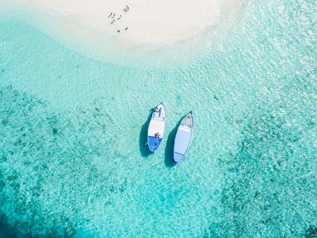aerial view of two blue boats