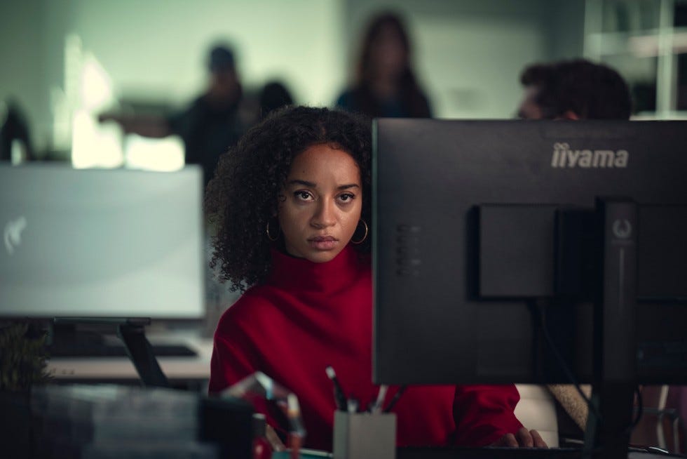 Siena Kelly in Black Mirror, sat at a computer and looking around the screen