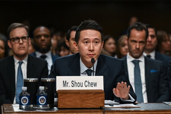 Shou Chew, the chief executive of TikTok, sitting at a table and speaking into a microphone.