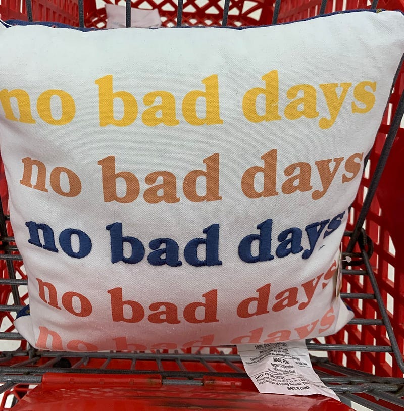 ID: Shopping cart with pillow on top that says no bad days repeatedly
