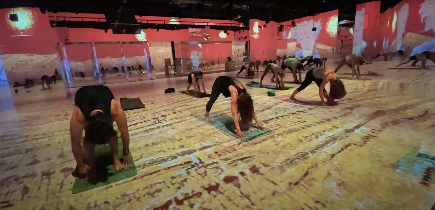 Figures doing immersive yoga at a class inside The Van Gough Experience exhibition. 