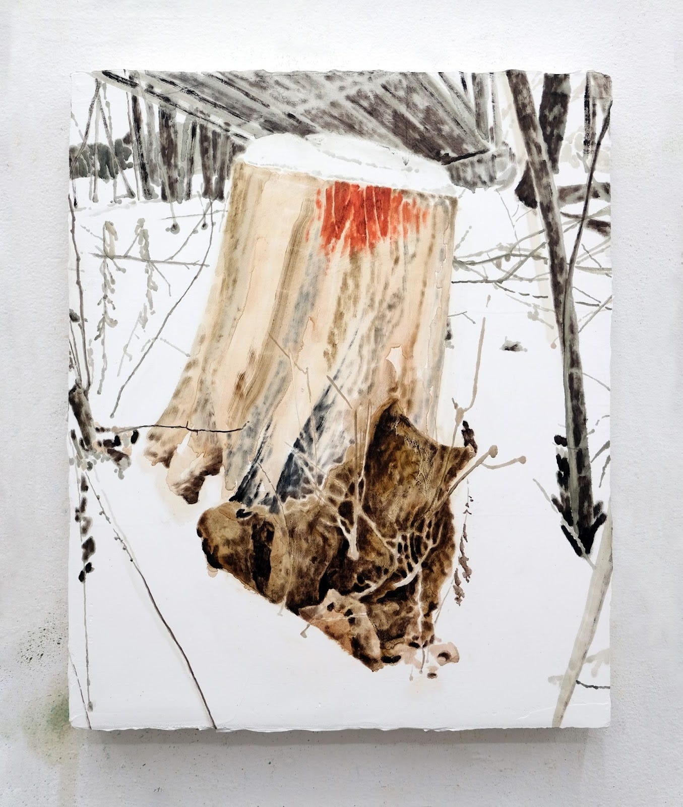 A painting of a wood stump in a snowy, wooded area hangs against a white wall. In the painting, the stump features a spot of red that could be interpreted as blood or a painted mark.