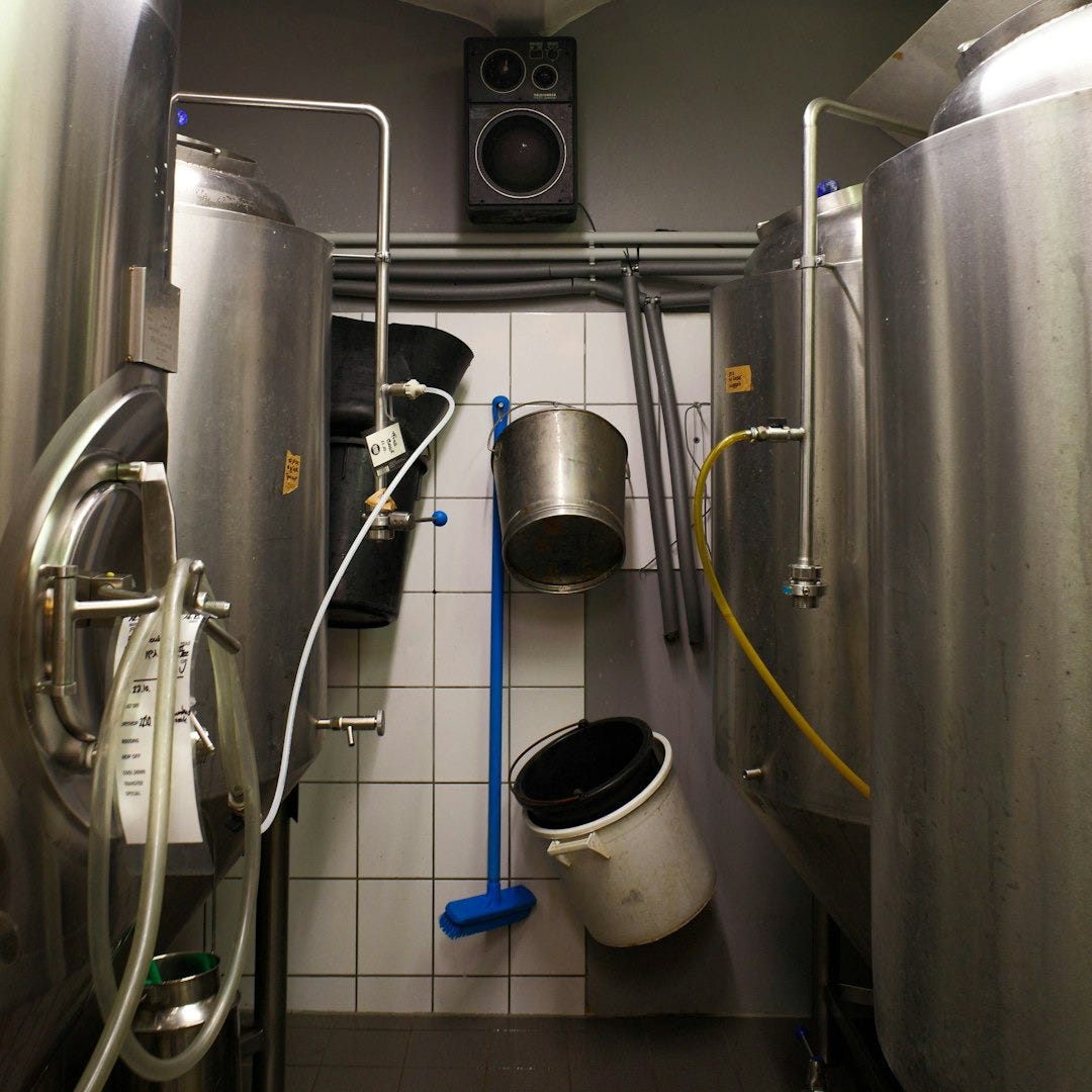 A room with a bunch of stainless steel tanks