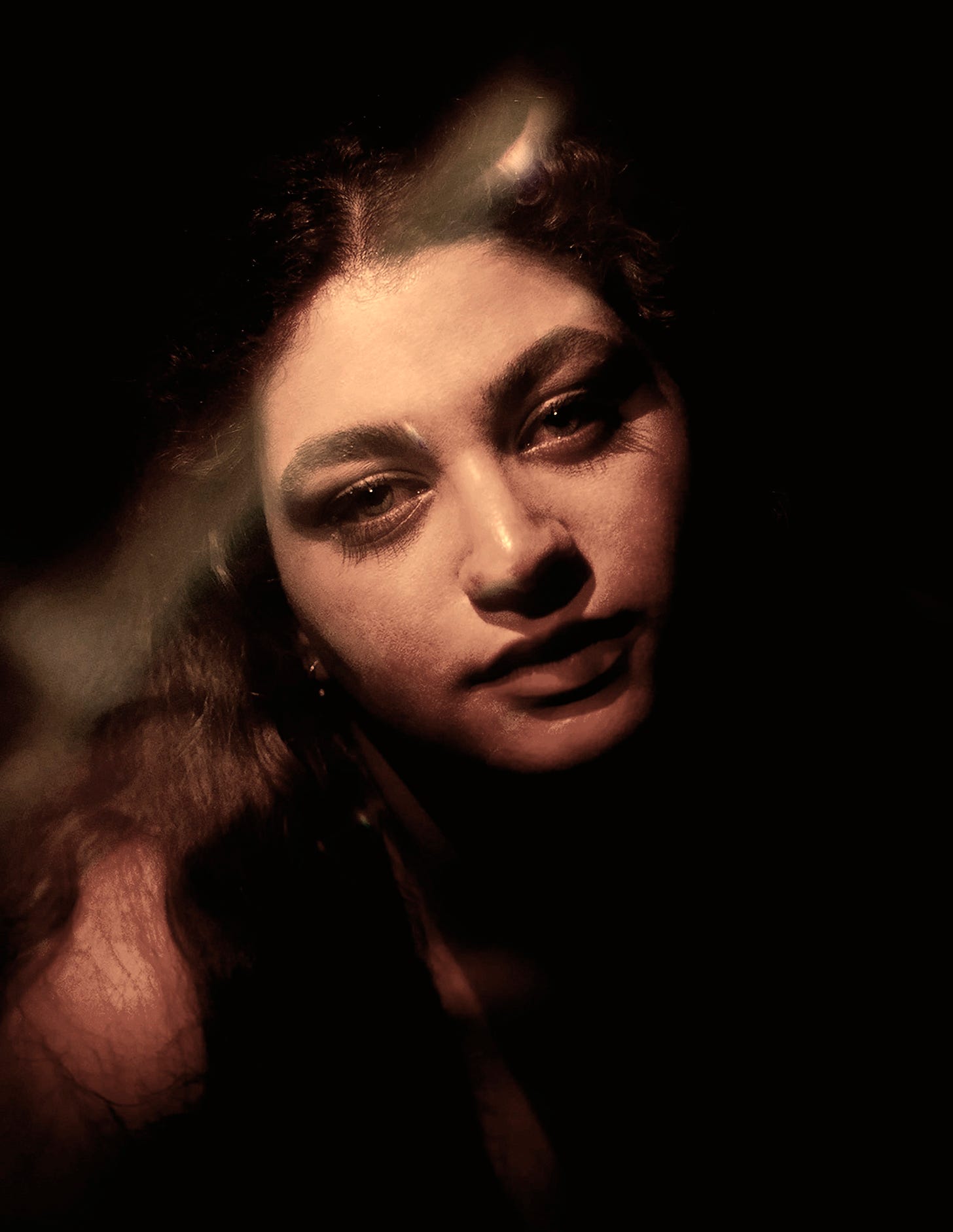 a woman in a dark room with her eyes closed