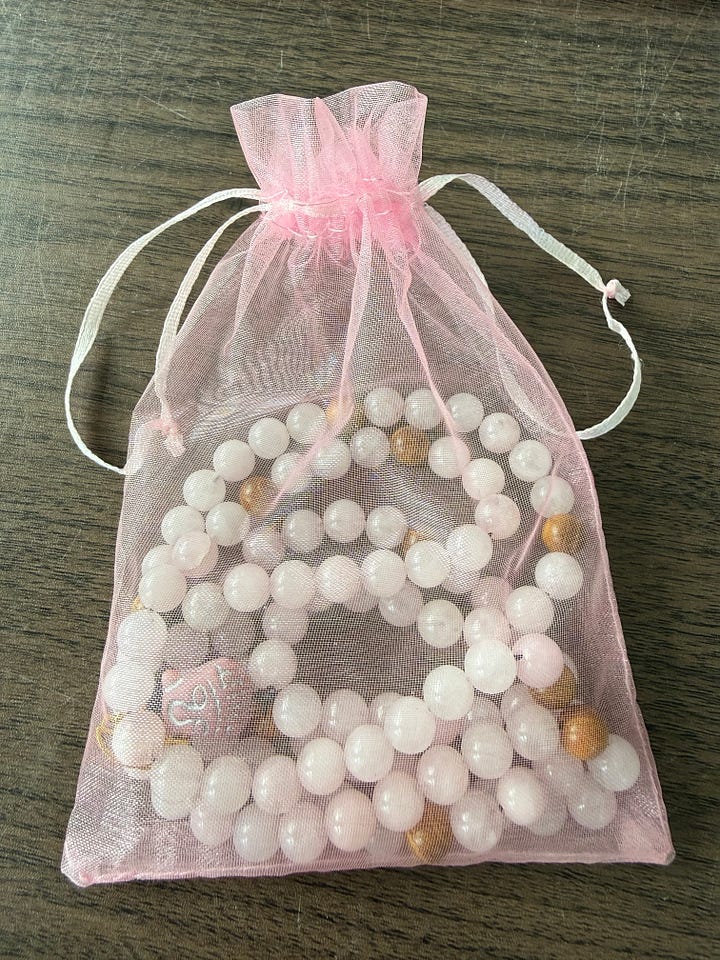 A variety of bead bracelets in various colors and pink mala beads and tiger's eye mala beads