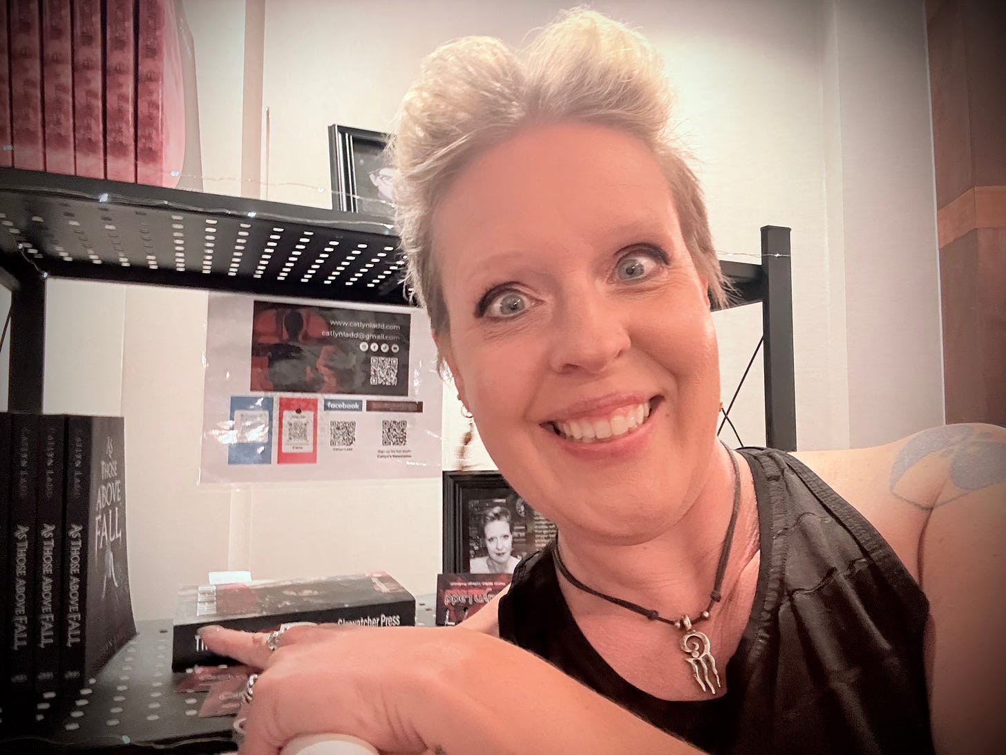 A grinning woman in front of a bookshelf