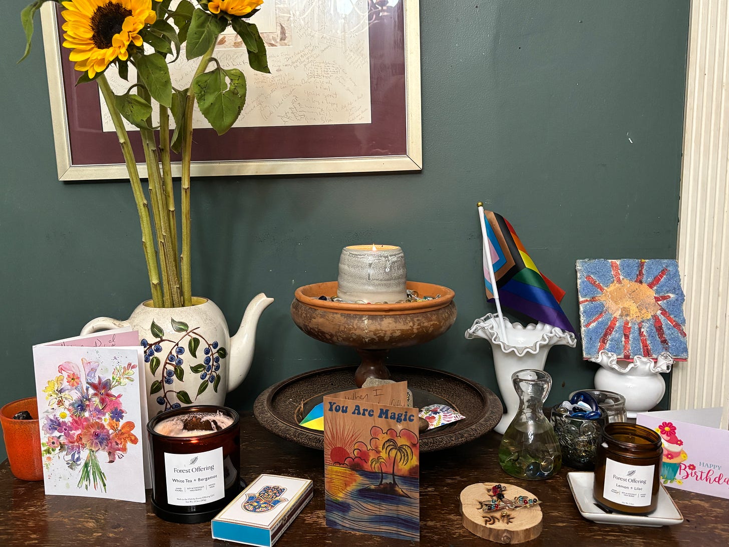 an altar with candles, stones and sunflowers