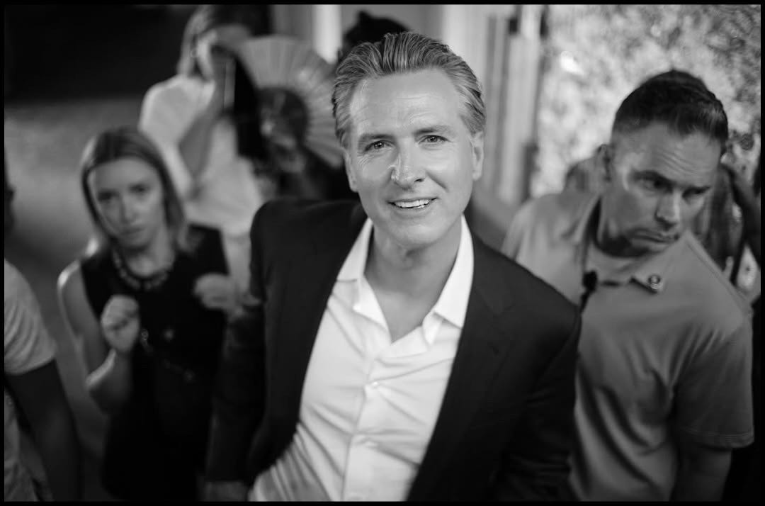 A photograph of California Gavin Newsom at an East Nashville gathering, perfectly capturing his self obsession.