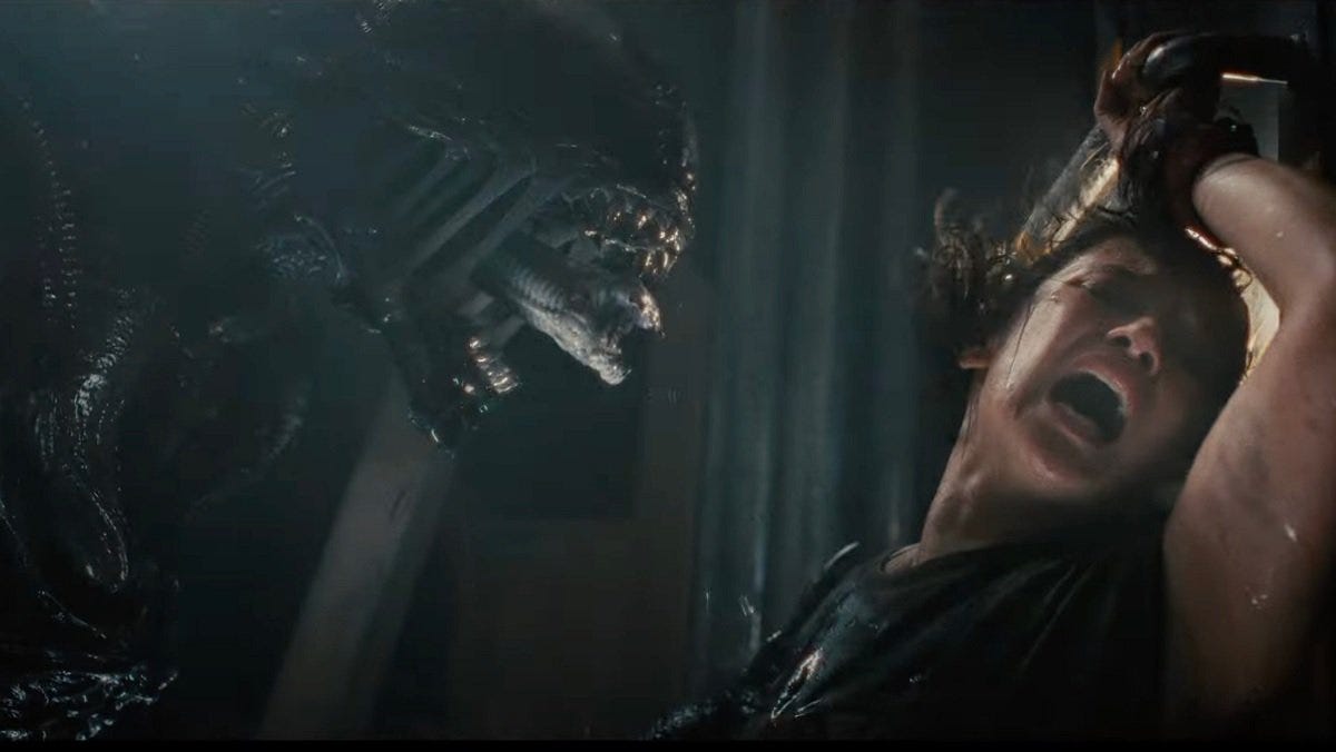 alien with two mouths and tongue leans in to feast on female victim who is screaming, as you would
