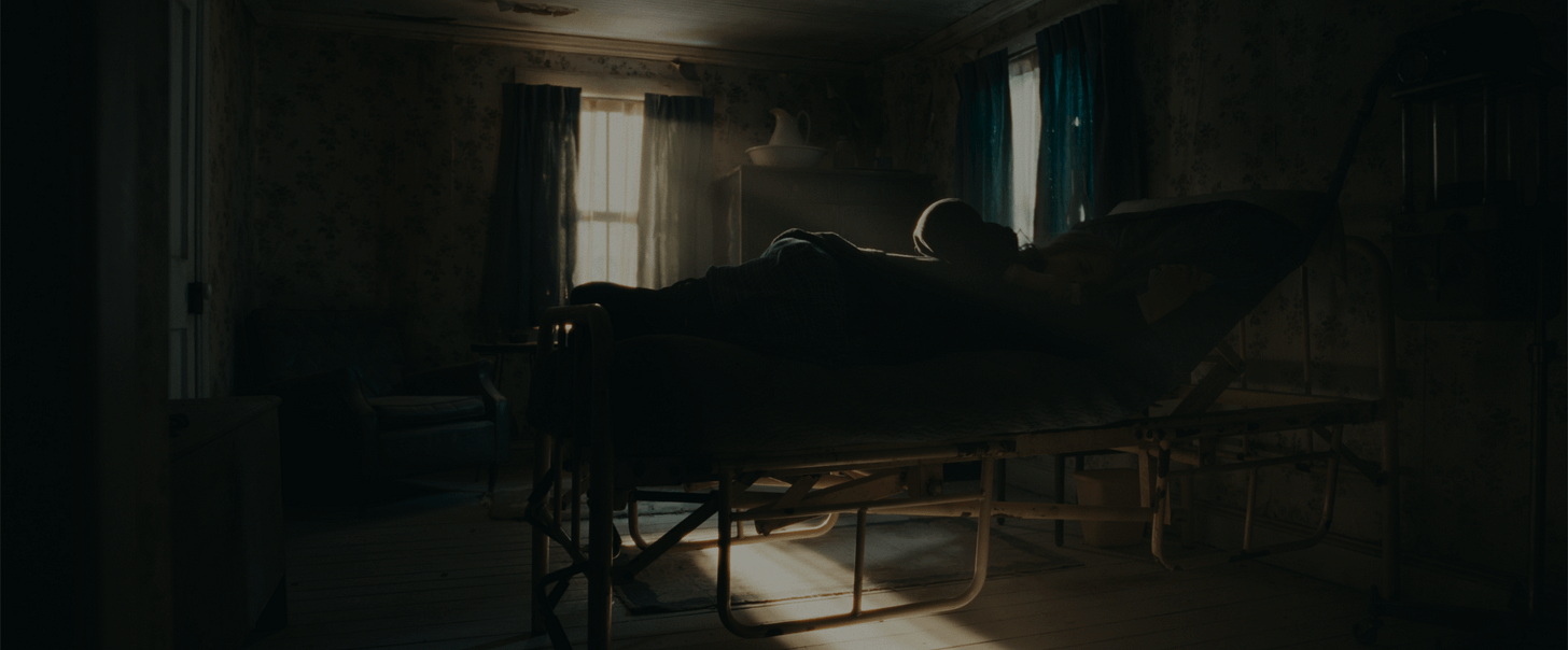 Harmony Cobel lying in her mother's old bed. Warm light is shining on her through the window