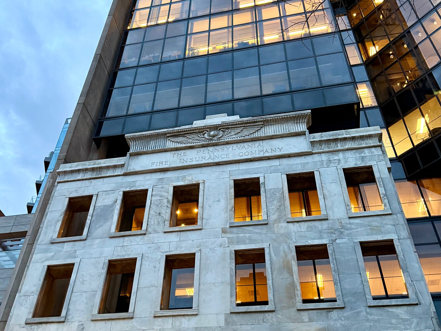 A modern skyscraper is overlaid with the original facade of an older stone building labeled "The Pennsylvania Fire Insurance Company"