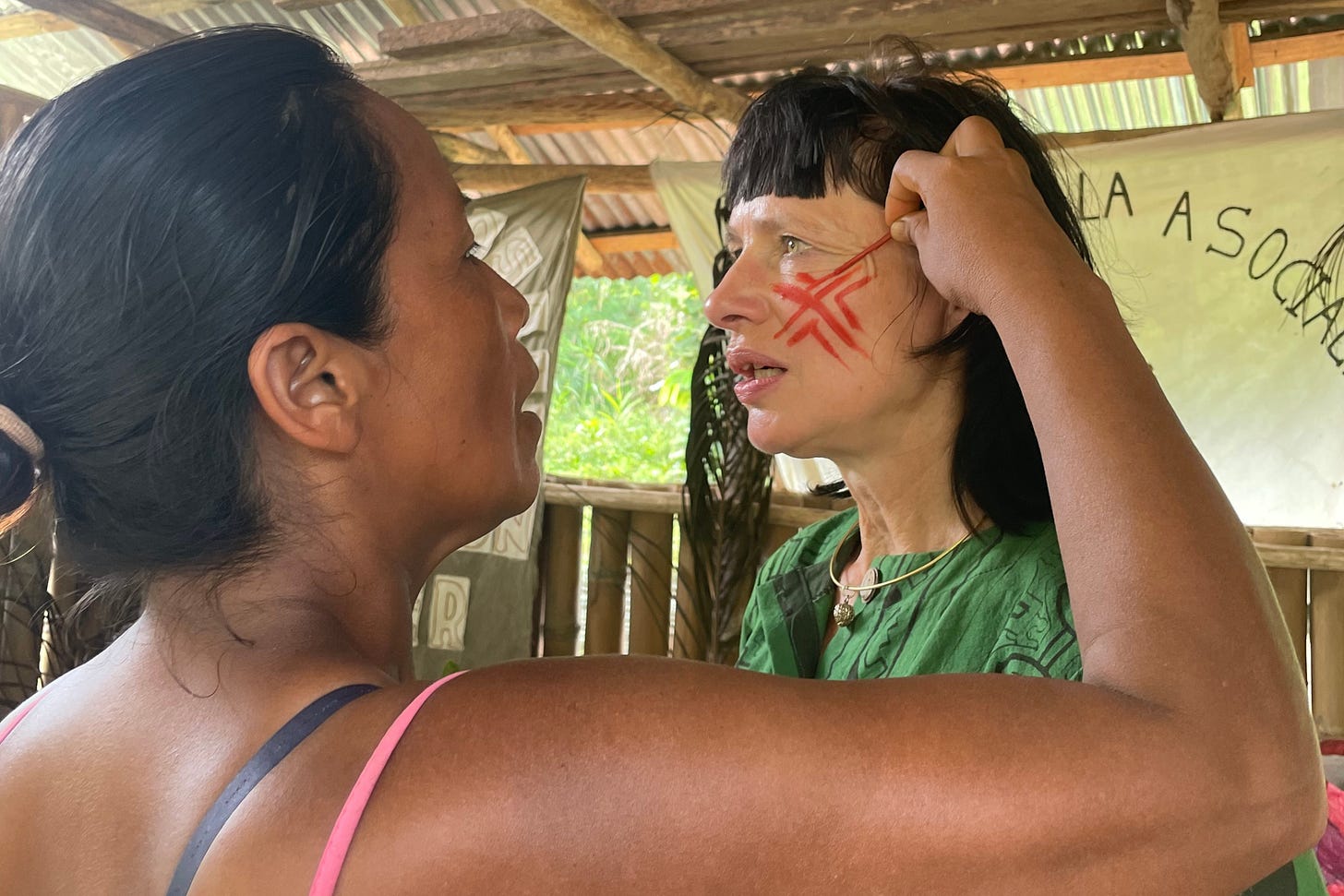 Carry Somers being painted with achiote by a Yanesha woman.