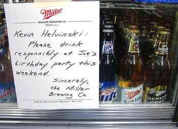 [Image shows a handwritten note on Miller Brewing Company letterhead displayed in front of beer bottles in what appears to be a refrigerator. The note reads:]  Kevin Helvinski: Please drink responsibly at Joe's birthday party this weekend.  Sincerely, The Miller Brewing Co.  [The letterhead includes the Miller logo and company address in Milwaukee, WI]