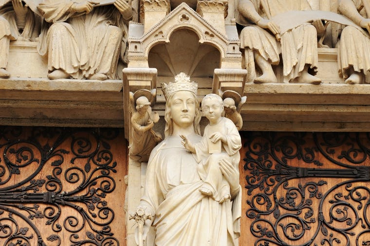 Statue of Mother and Child at the entrance of Notre Dame in Paris