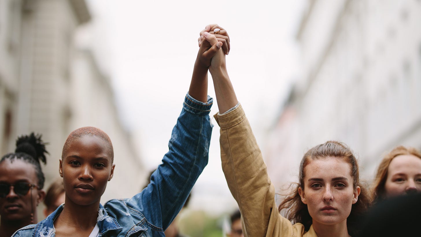 Two women, arms raised in protest