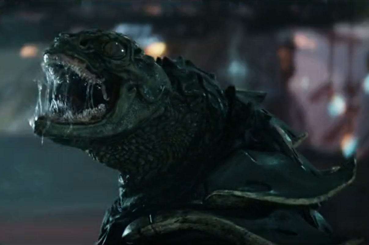 A juvenile Gorn snarls with its mouth wide open, showing rows of sharp teeth and dark, armored scales. A juvenile Gorn snarls with its mouth wide open, showing rows of sharp teeth and dark, armored scales.
