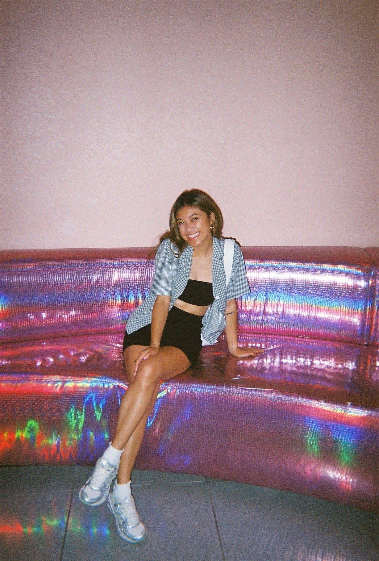 Samantha sits on a pink couch. 
