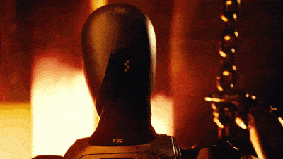 Close-up of a matte black humanoid robot head and upper torso marked "F02" slowly turning in warm orange backlight next to an ornate metal candlestick. Close-up of a matte black humanoid robot head and upper torso marked "F02" slowly turning in warm orange backlight next to an ornate metal candlestick.
