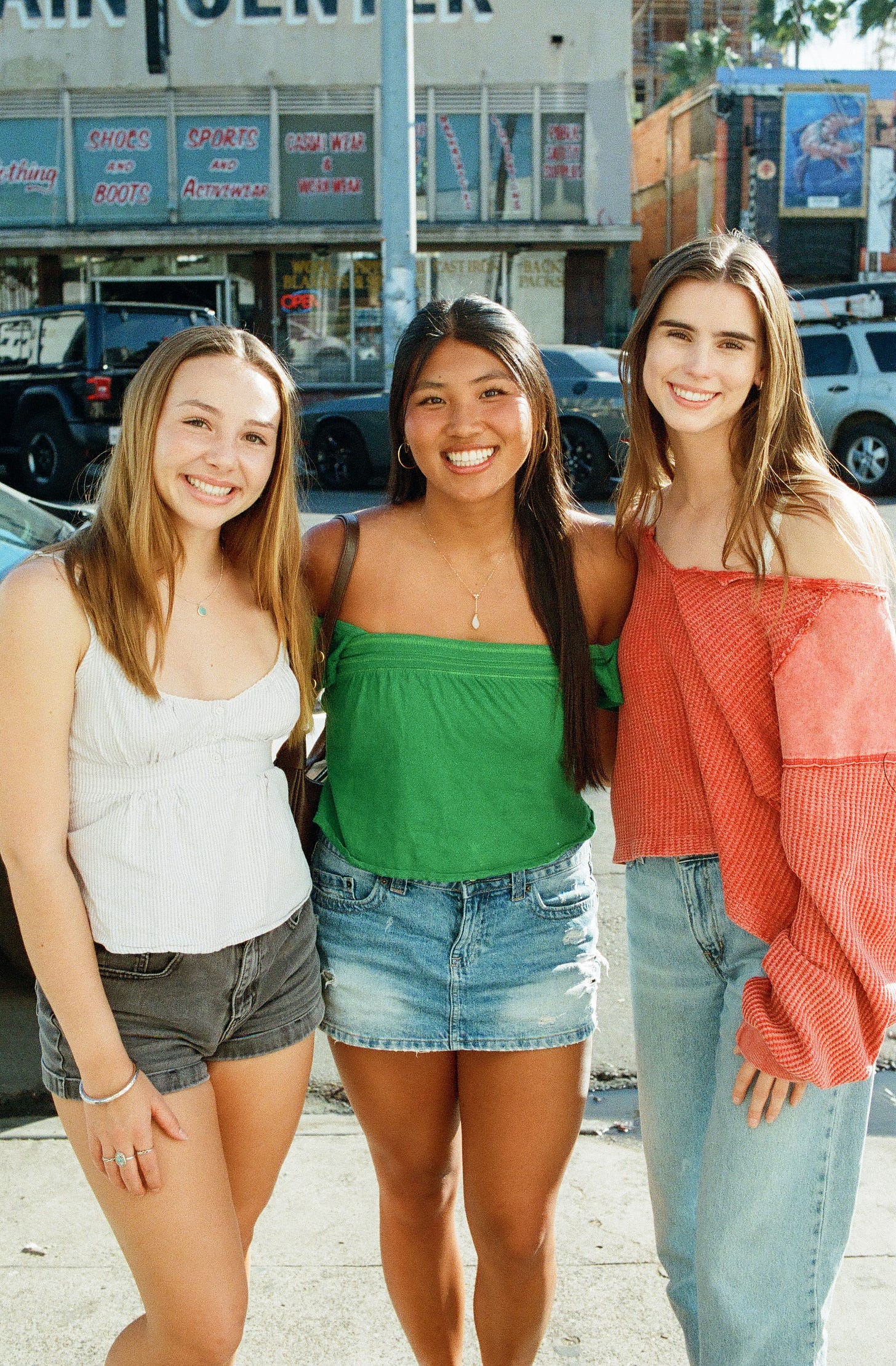 Three stylish friends standing and smiling for a portrait outside Lovesong Coffee in North Park San Diego