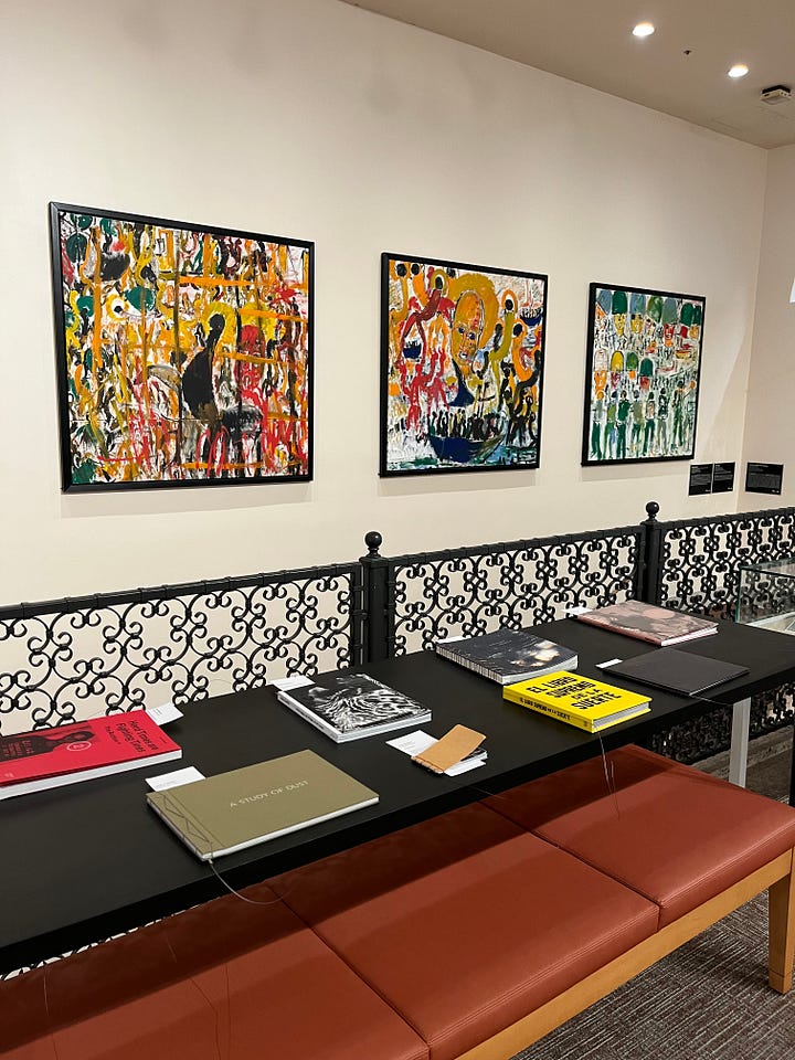 top left: exterior of Miami Pubic Library with Spanish tile courtyard; top right: view from second floor mezzanine looking down at the lobby of the Miami Public Library with orange tile floors and a central information desk; bottom left: books on the library shelf by Micol Ostow; bottom right: some art and special collections on the second floor