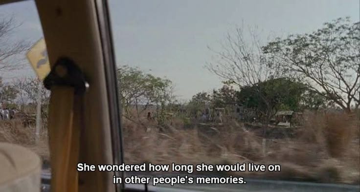 This may contain: the back window of a car looking out at an open field with trees and bushes