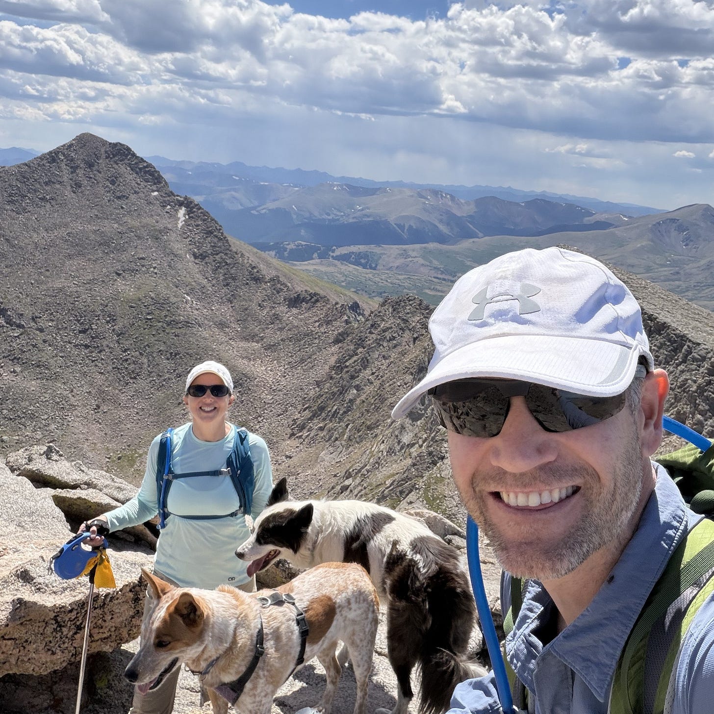 a man, woman and two dogs on a mountain top in Colorado a man, woman and two dogs on a mountain top in Colorado